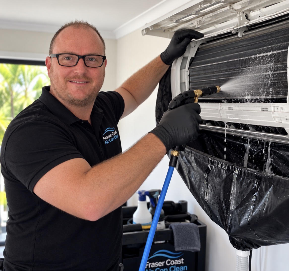 Justin, owner of Fraser Coast Air Con Clean, deep cleaning a split system air conditioner in a Hervey Bay home